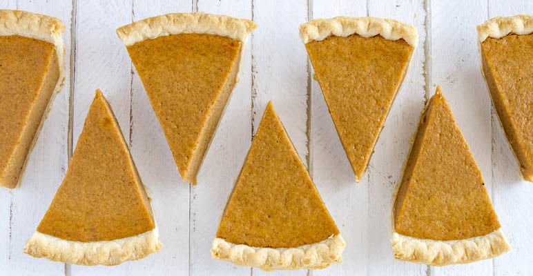 Seven slices of homemade pumpkin pie in a row