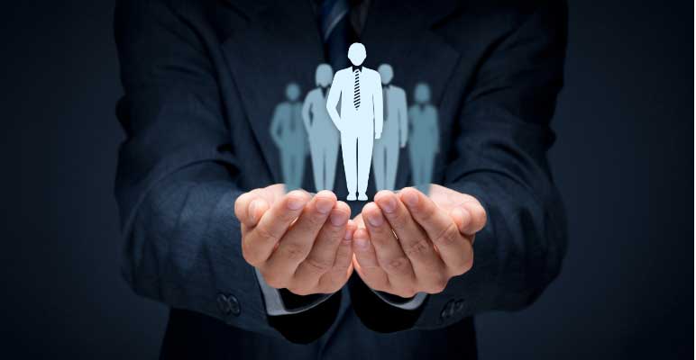 La photo du torse d’un homme d’affaires, bras sont étendus, mains jointes avec les paumes vers le haut, et tenant des silhouettes superposées de petits gens d’affaires.